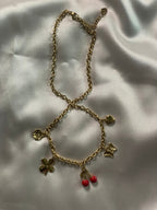 Collier à chaîne dorée orné de charms sur soie