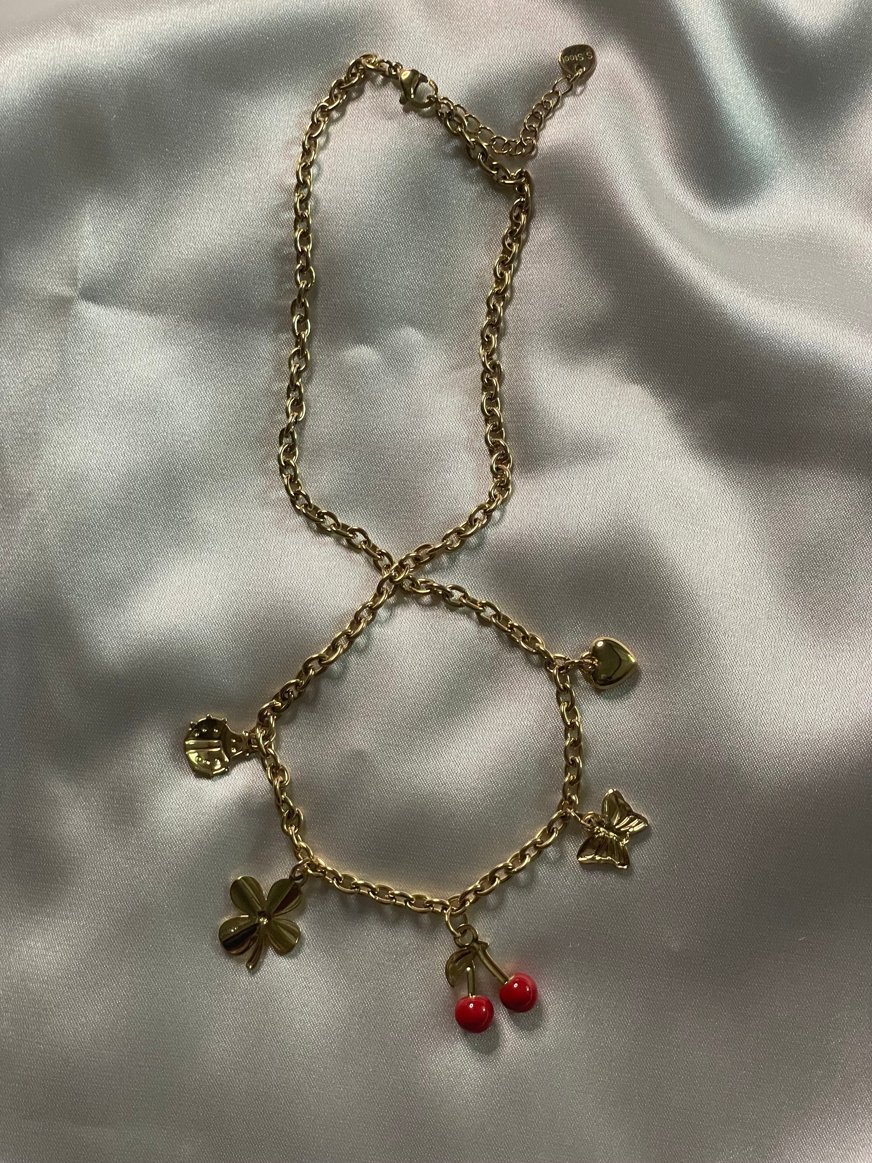 Collier à chaîne dorée orné de charms sur soie